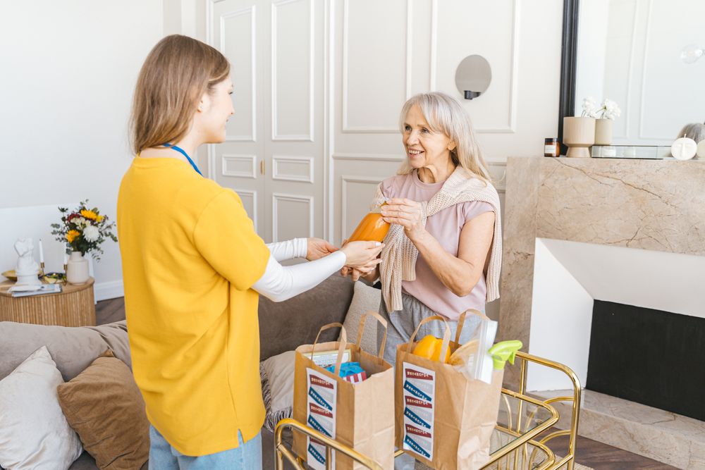 A caregiver helping a senior client with groceries at home